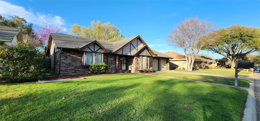a view of a house with a big yard plants and large trees