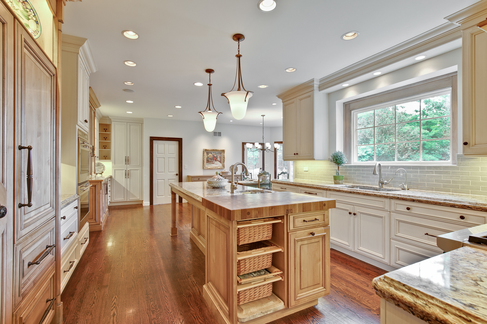 433 South Ridge Road Lake Forest, IL 60045 - Photo 18 of 49 a kitchen with kitchen island granite countertop a stove a sink a refrigerator and a dining table with wooden floor