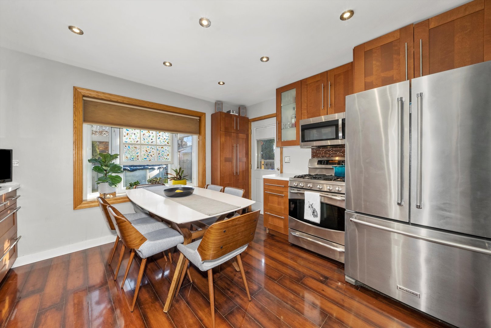 735 Forest Road La Grange Park, IL 60526 - Photo 11 of 31 a kitchen with stainless steel appliances a refrigerator a stove a sink and a dining table with wooden floor
