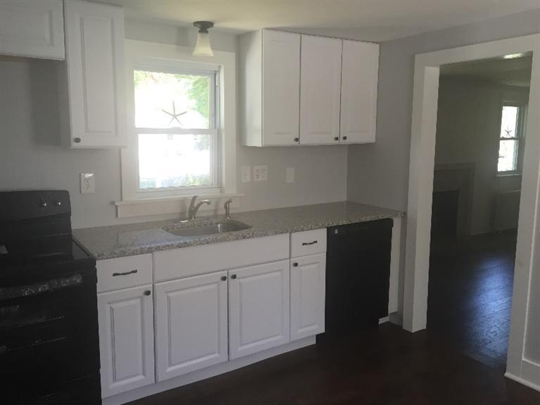 129 Spring Street Hyannis, MA 02601 - Photo 11 of 31 a kitchen with white cabinets and sink