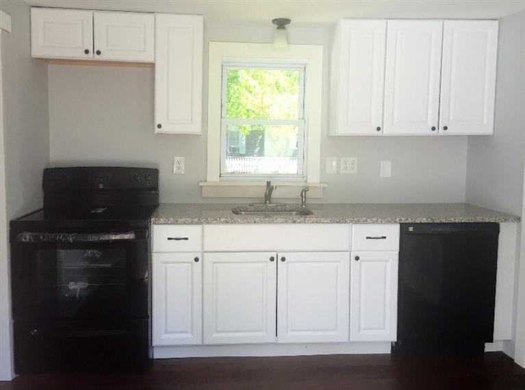 129 Spring Street Hyannis, MA 02601 - Photo 10 of 31 a kitchen with granite countertop white cabinets and black appliances