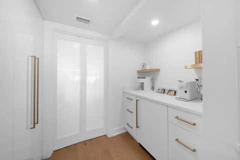 a view of a kitchen with wooden floor and electronic appliances
