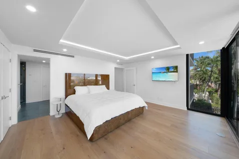 a large white bed sitting in a room next to a balcony