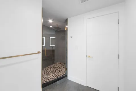 a bathroom with a glass shower door and a sink