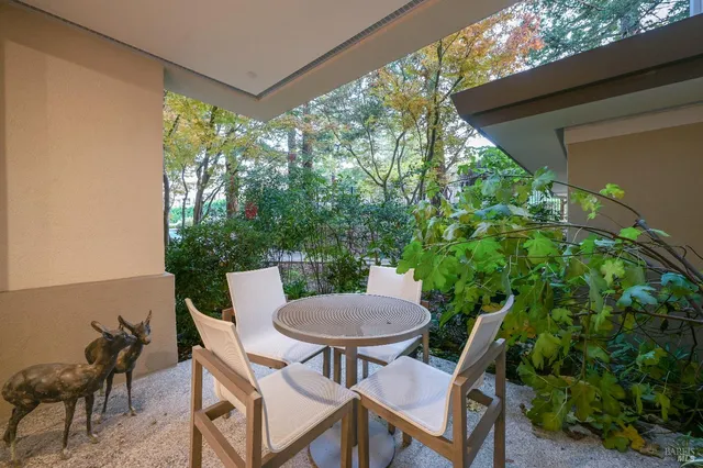 a view of a patio with a table chairs and a yard