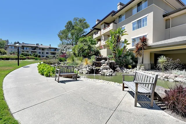 a view of a chair and tables in the back yard of the house