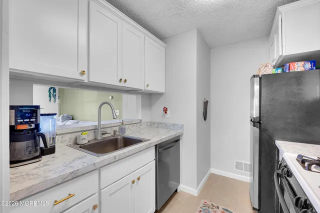 a kitchen with a sink cabinets and stainless steel appliances