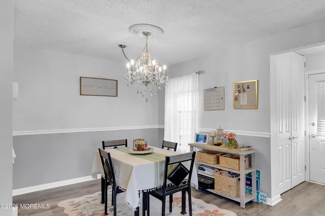 a view of a dining room with furniture a chandelier and wooden floor