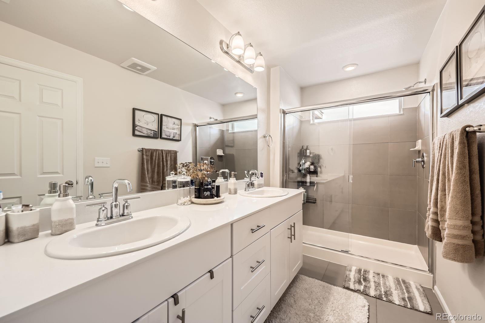 5142 Bittercress Road Brighton, CO 80640 - Photo 8 of 11 a bathroom with a double vanity sink mirror double and shower