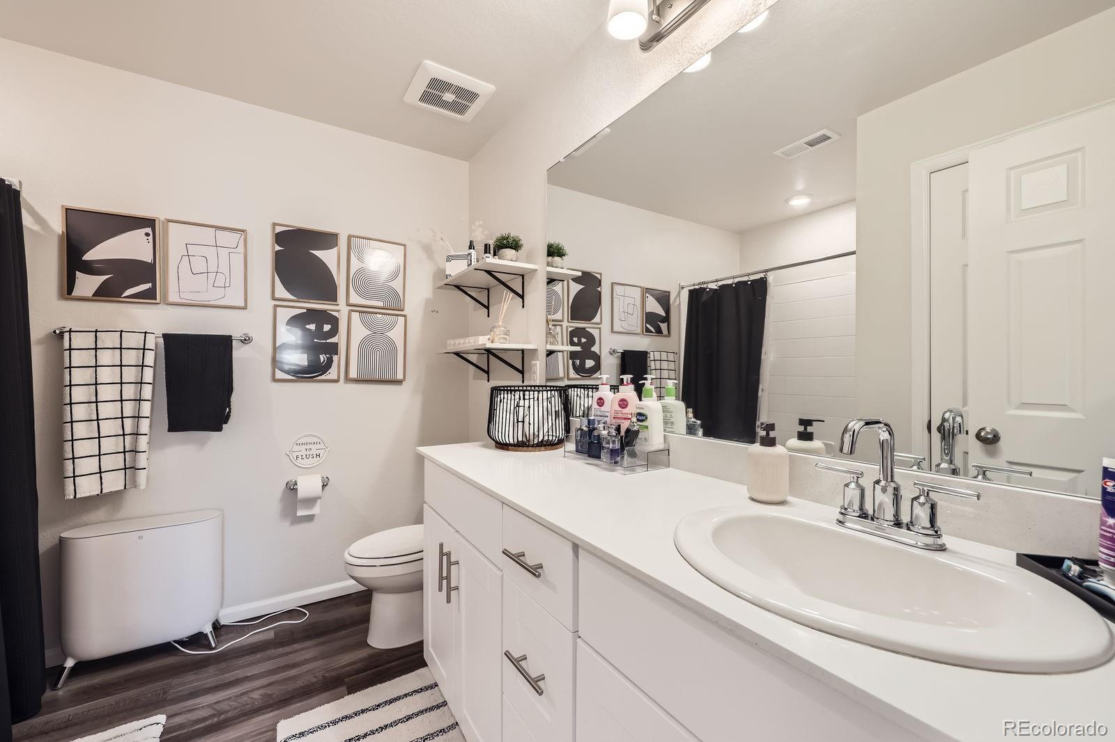 5142 Bittercress Road Brighton, CO 80640 - Photo 10 of 11 a bathroom with double vanity a toilet a sink and mirror