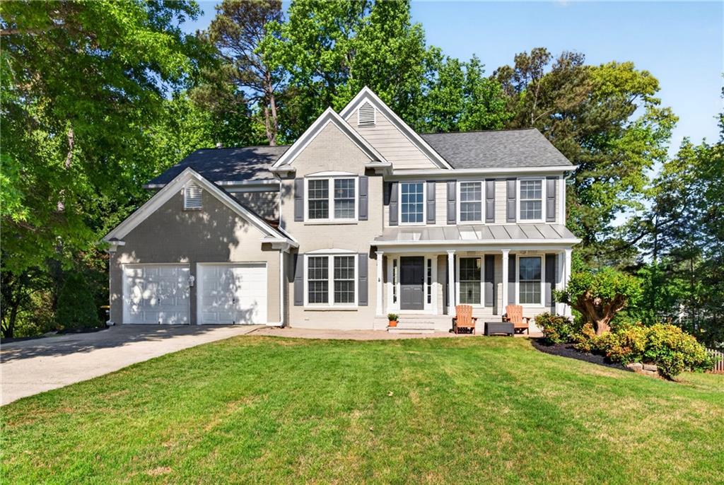 7830 Llangollen Way Cumming, GA 30041 - Photo 2 of 60 a front view of a house with a yard table and chairs