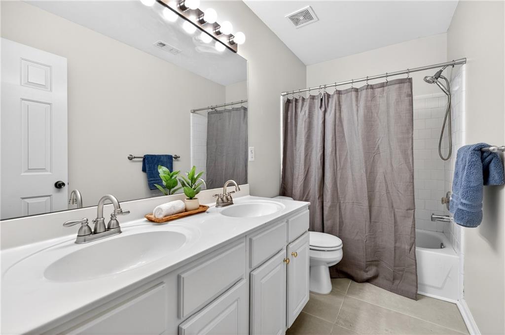 7830 Llangollen Way Cumming, GA 30041 - Photo 43 of 60 a bathroom with a sink a toilet and shower curtain