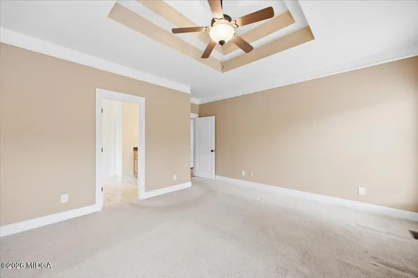 an empty room with chandelier fan