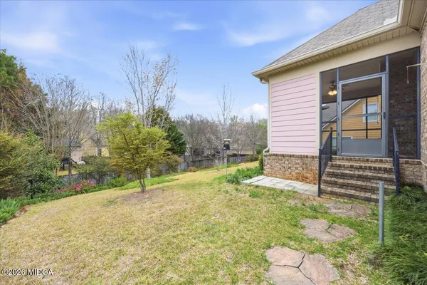 a view of a house with backyard and trees