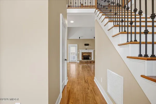 a view of a hallway with wooden floor and staircase