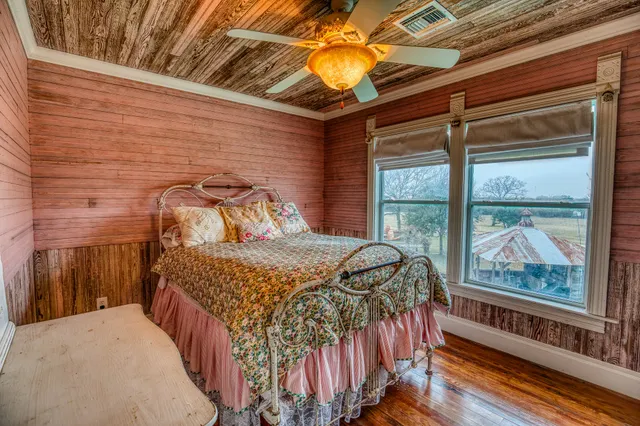 a bedroom with a bed and a large window