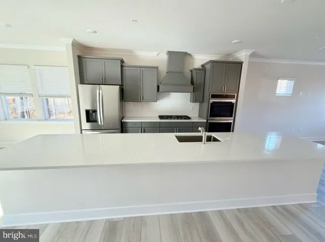 a kitchen with kitchen island stainless steel appliances a sink and cabinets