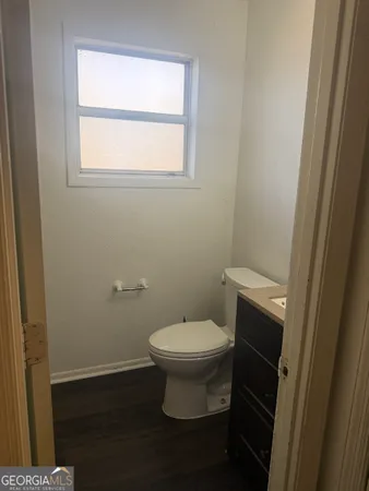 a white toilet sitting in a bathroom next to a window