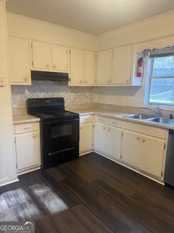 a kitchen with cabinets appliances and a sink