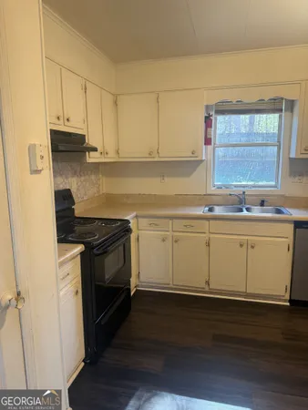 a kitchen with granite countertop white cabinets and white appliances
