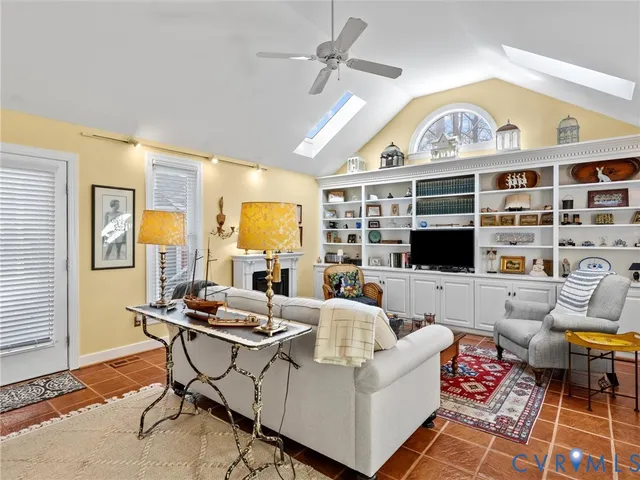 a living room with furniture a fireplace and a flat screen tv