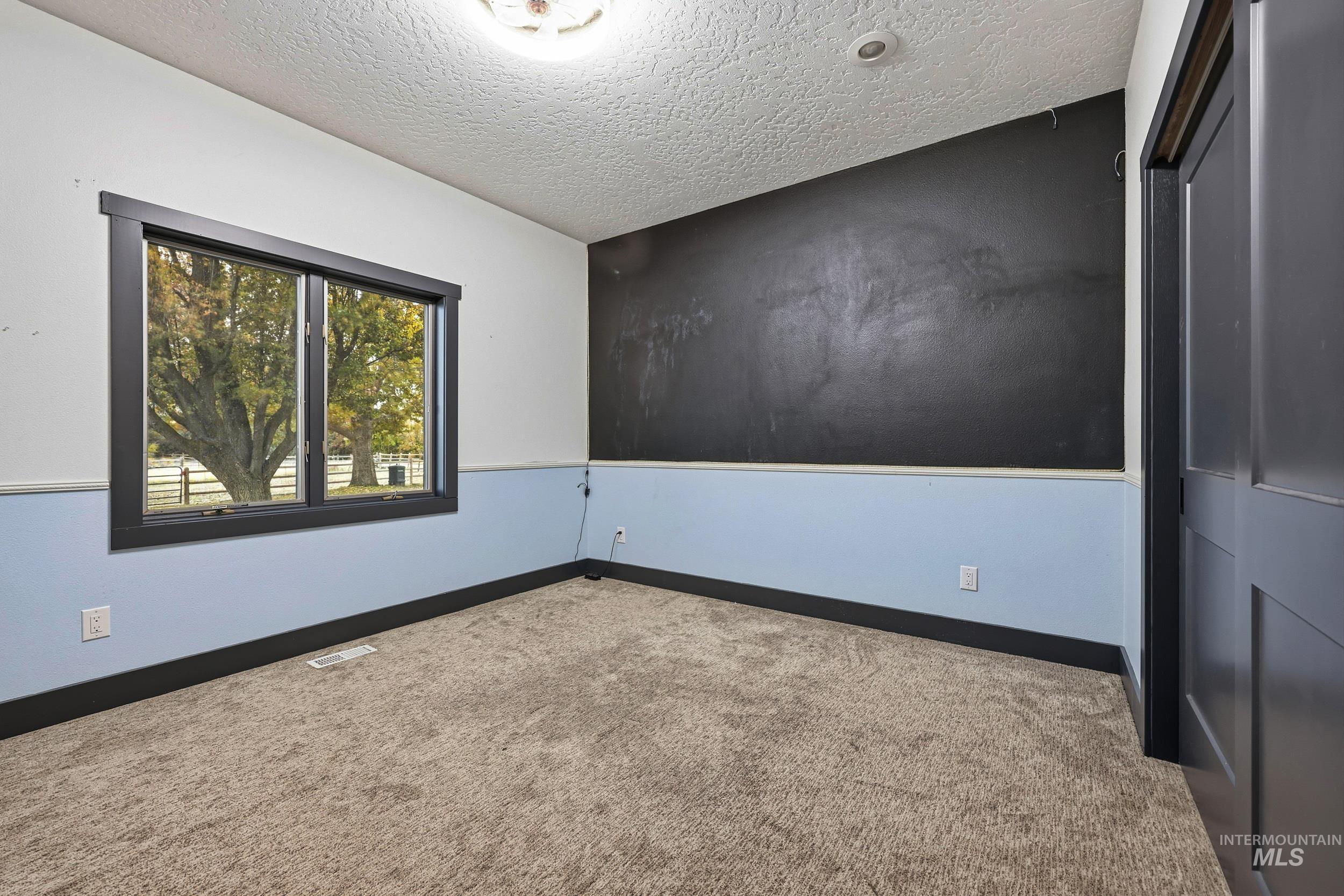 25300 Harvey Road Caldwell, ID 83607 - Photo 20 of 50 Spare room featuring a textured ceiling and carpet floors