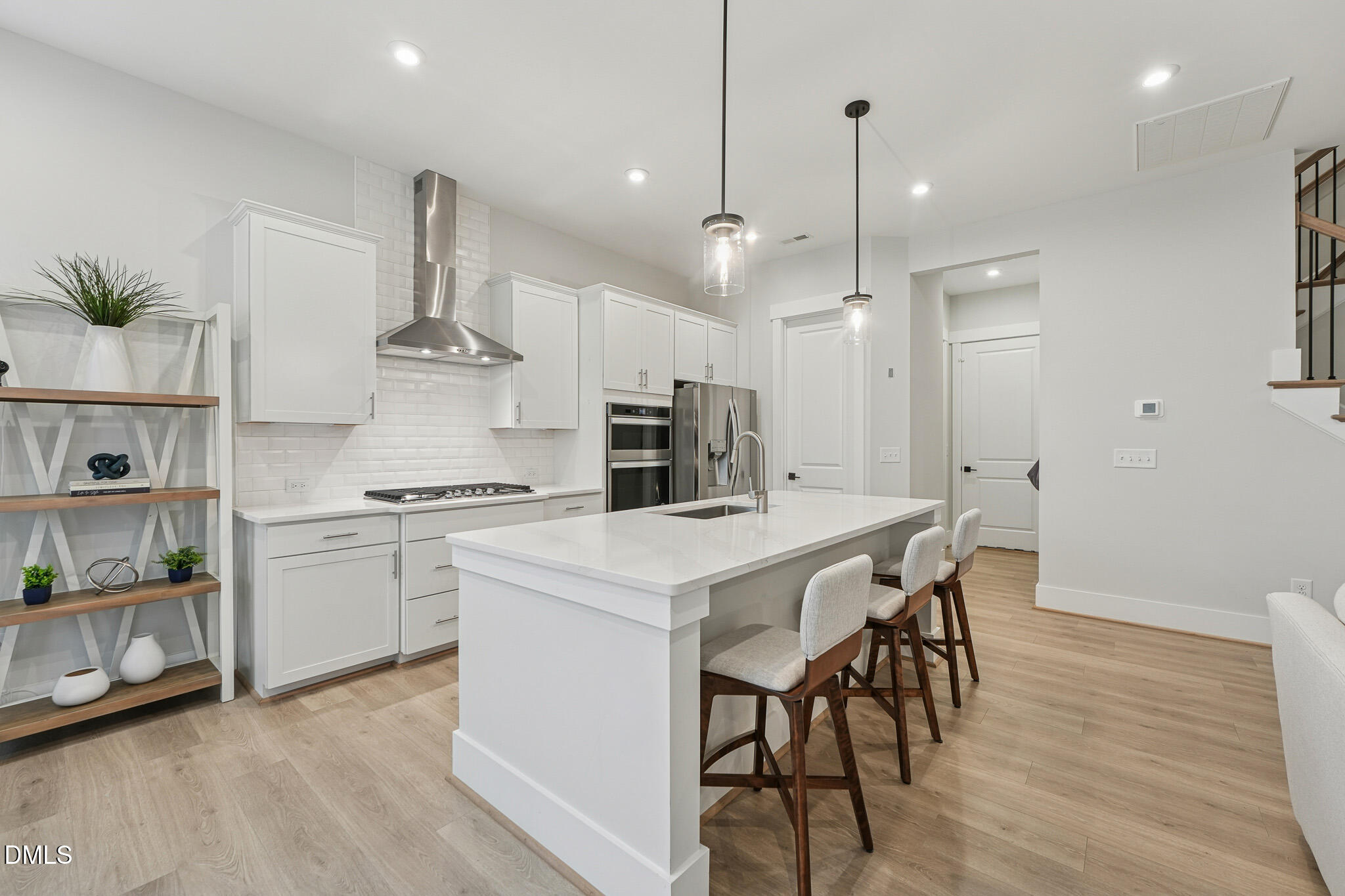 5208 Windmere Chase Drive Raleigh, NC 27616 - Photo 10 of 42 a kitchen with stainless steel appliances a stove a sink a kitchen island with a dining table and chairs