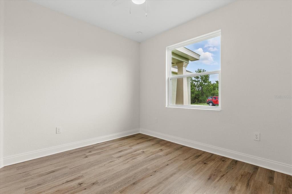 4457 Romano Street Sebring, FL 33872 - Photo 15 of 23 an empty room with wooden floor and window