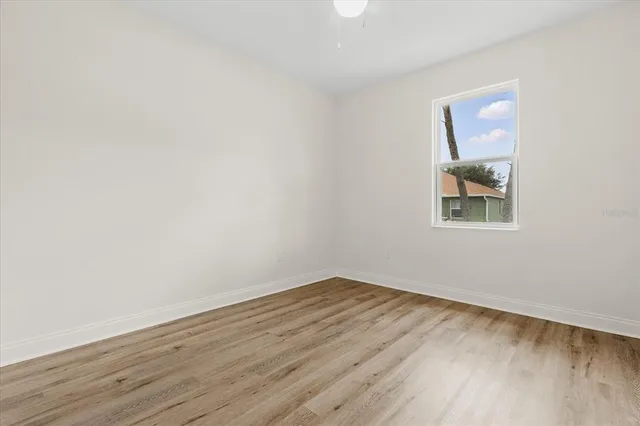 an empty room with wooden floor and painting on the wall