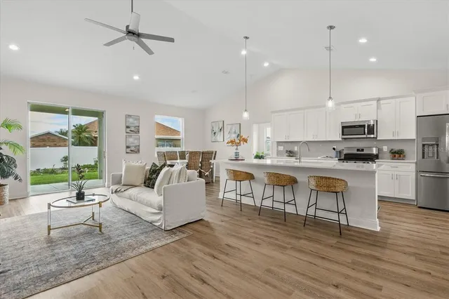 a living room with lots of furniture and kitchen view