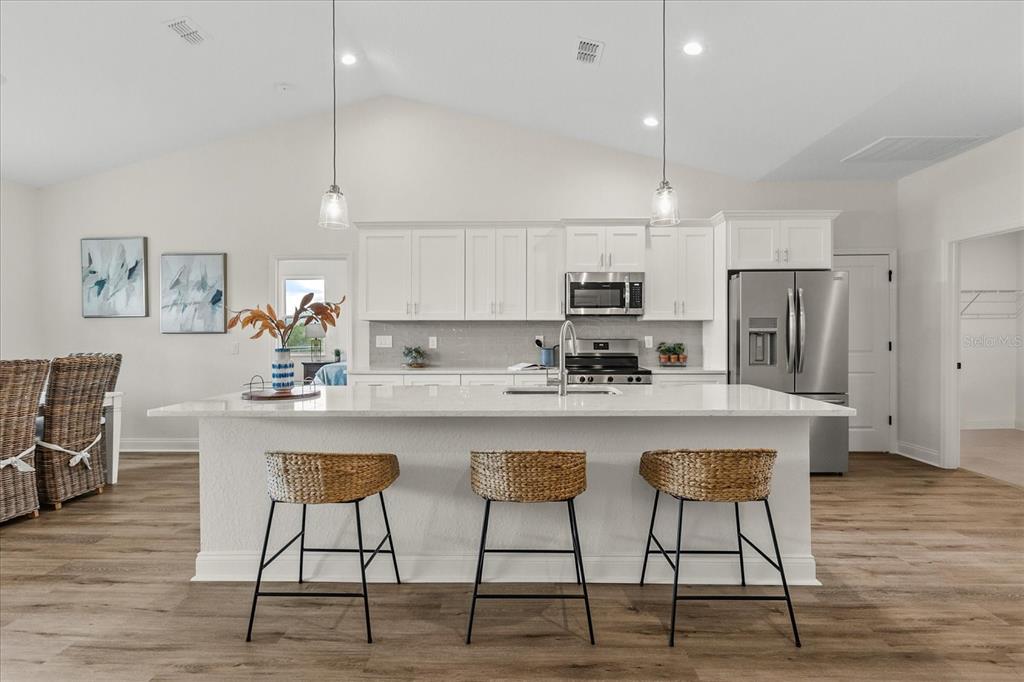 4457 Romano Street Sebring, FL 33872 - Photo 8 of 23 a kitchen with stainless steel appliances granite countertop a table chairs microwave and sink