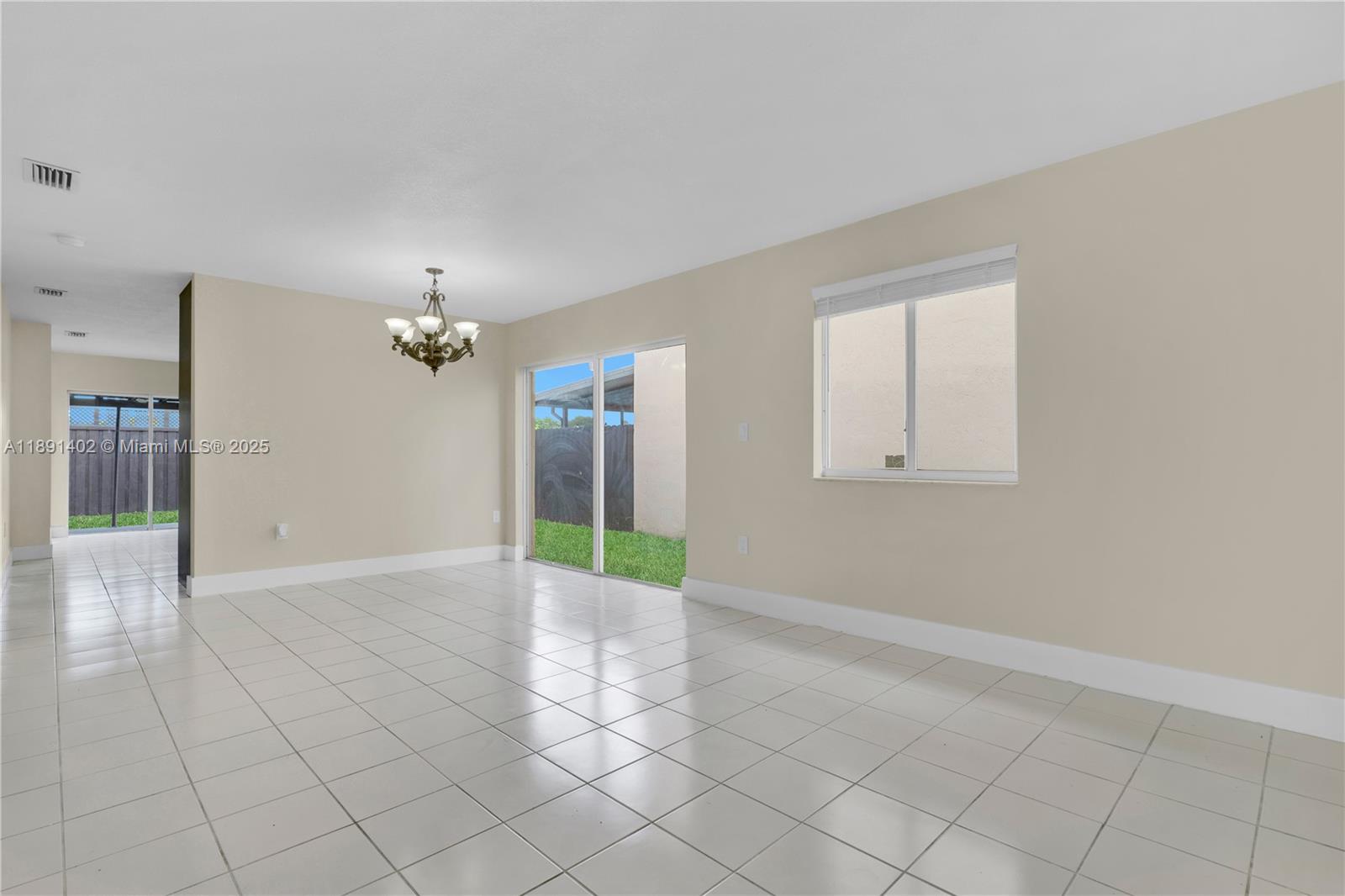 16215 Southwest 137th Court Miami, FL 33177 - Photo 11 of 30 an empty room with chandelier fan and windows