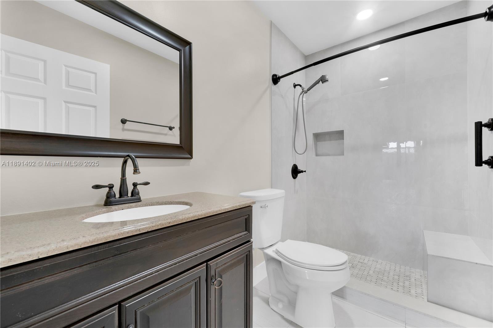 16215 Southwest 137th Court Miami, FL 33177 - Photo 24 of 30 a bathroom with a sink a toilet a mirror and shower