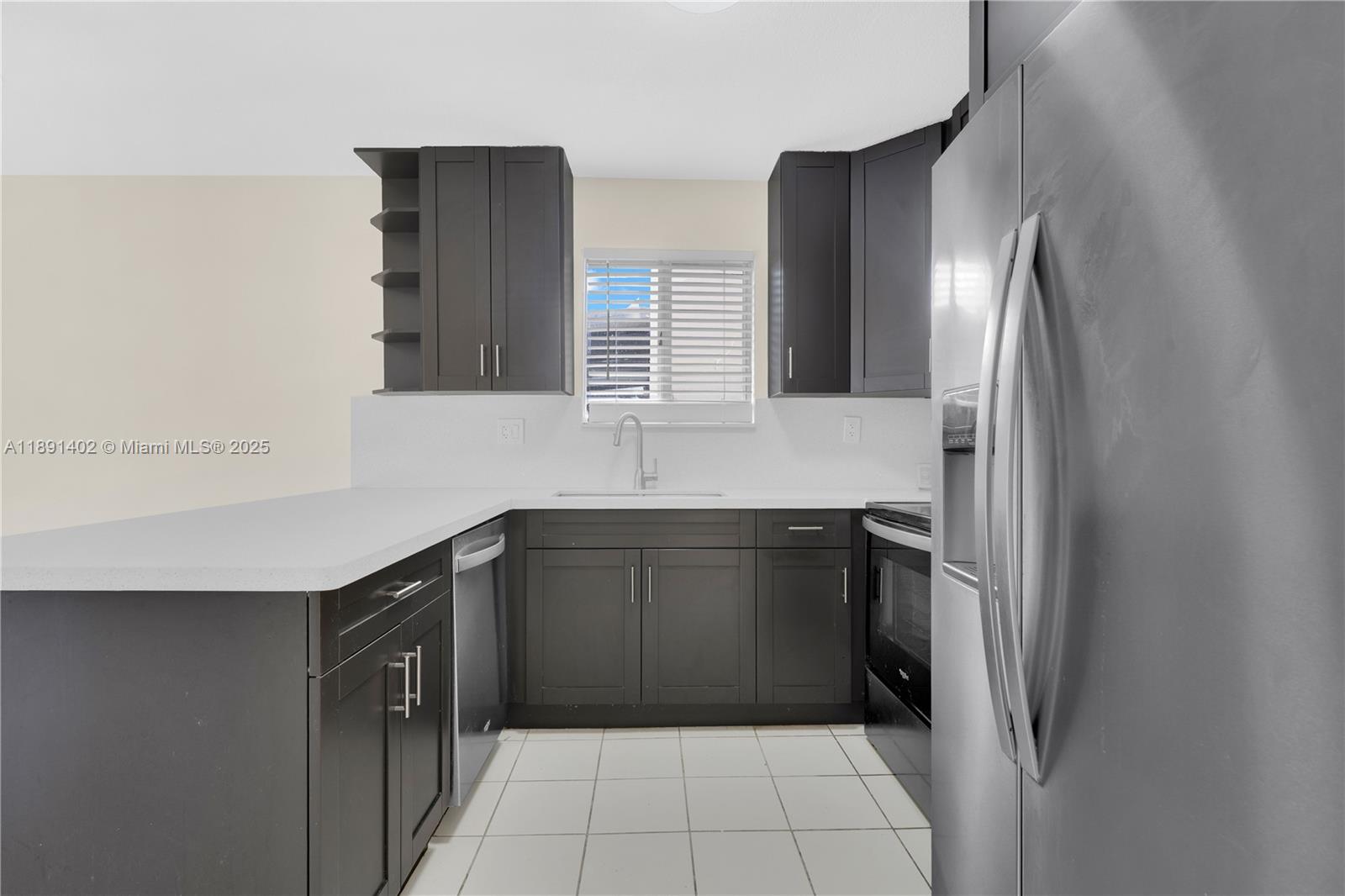 16215 Southwest 137th Court Miami, FL 33177 - Photo 5 of 30 a kitchen with a sink and a refrigerator