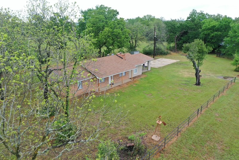 a view of a house with a yard and trees