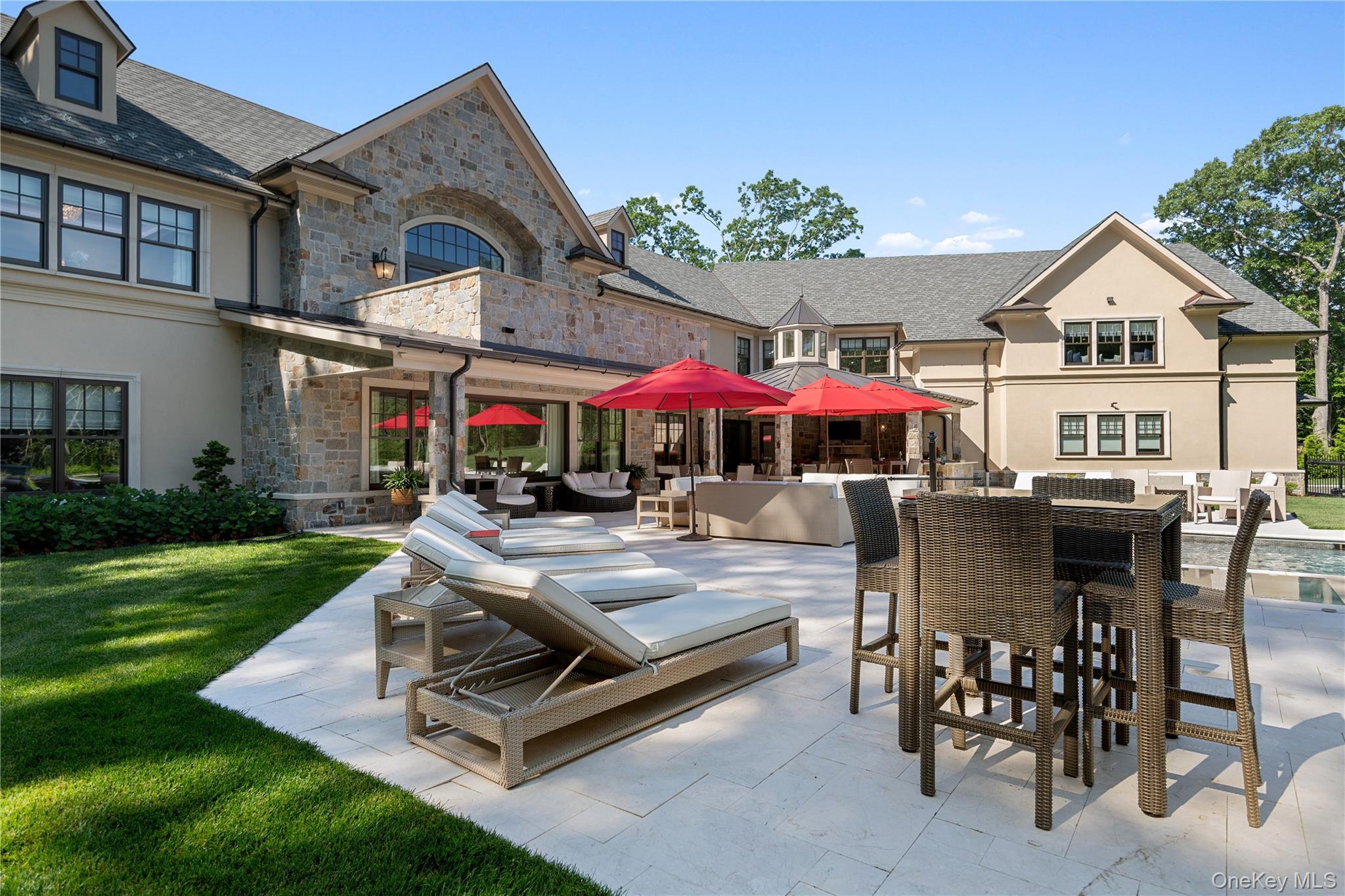 471 Woodbury Road Cold Spring Harbor, NY 11724 - Photo 33 of 36 a view of a patio with dining table and chairs under an umbrella