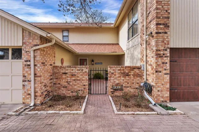 a view of a brick house with large windows