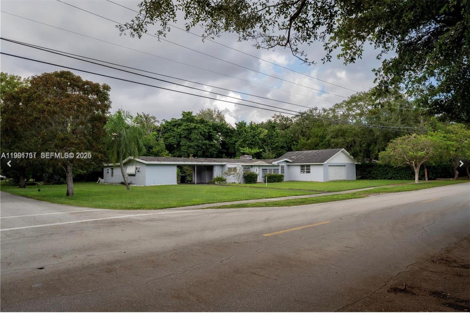 8045 Southwest 128th Street Pinecrest, FL 33156 - Photo 9 of 11 a front view of a house with a yard