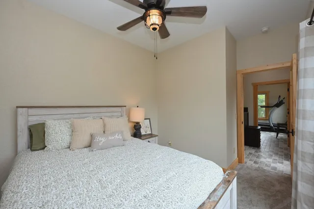 a view of a hallway with a bedroom and a chandelier fan