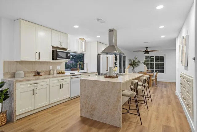 a large kitchen with stainless steel appliances granite countertop a lot of counter space and wooden floors