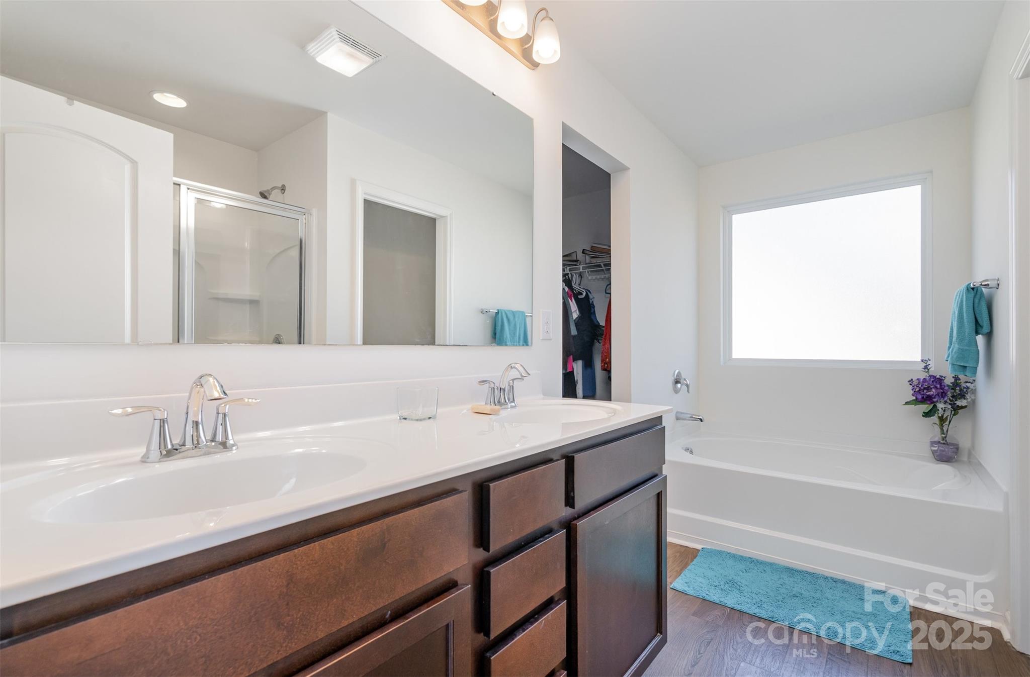 8009 Camden Crossing Lowell, NC 28098 - Photo 14 of 20 a bathroom with a sink a large mirror and a bathtub