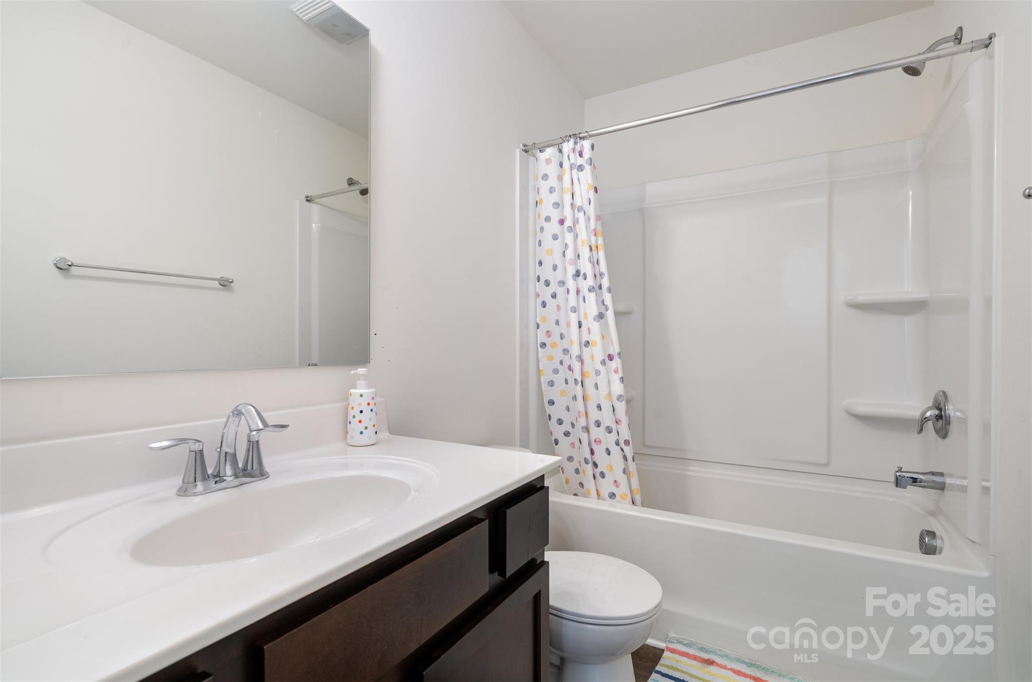 8009 Camden Crossing Lowell, NC 28098 - Photo 16 of 20 a bathroom with a sink a toilet a mirror a bathtub and shower