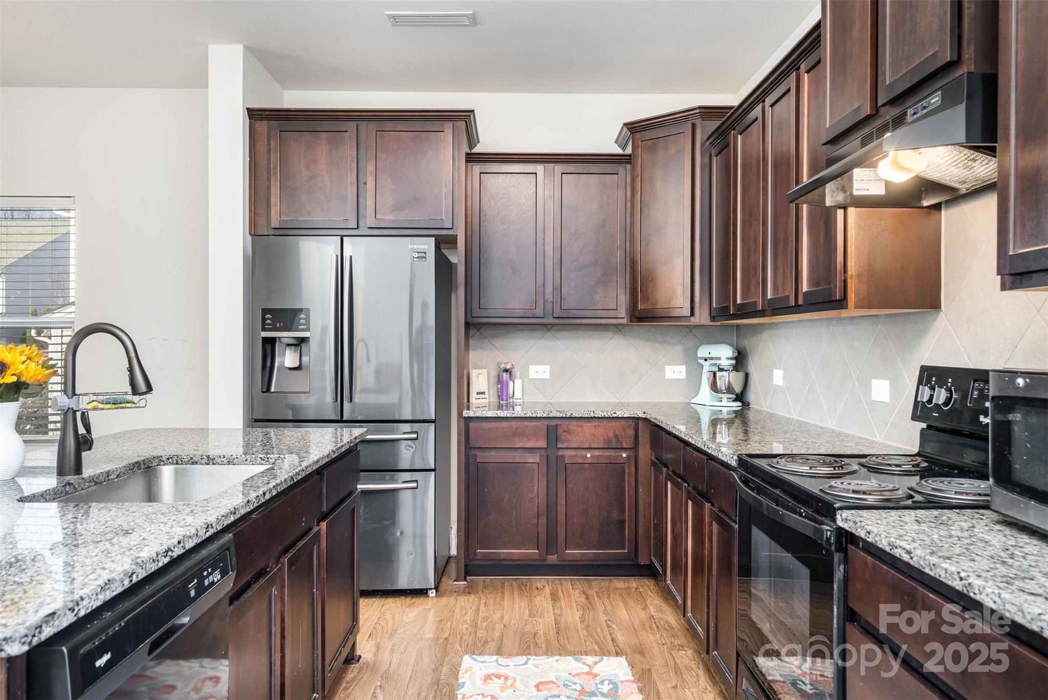 8009 Camden Crossing Lowell, NC 28098 - Photo 5 of 20 a kitchen with stainless steel appliances granite countertop a sink stove and refrigerator