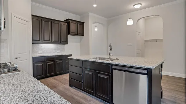 a kitchen with a sink cabinets and wooden floor