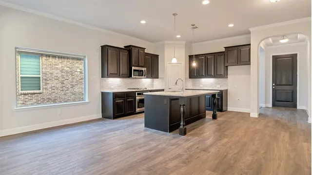 a kitchen with granite countertop a sink stove and cabinets