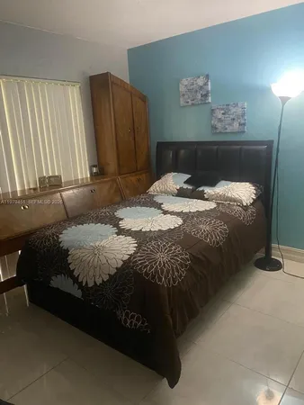 a bedroom with a bed and painting on the wall
