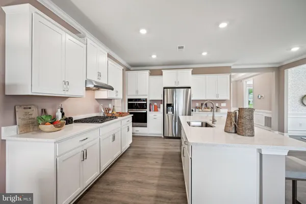 a kitchen with stainless steel appliances kitchen island granite countertop a refrigerator and a sink
