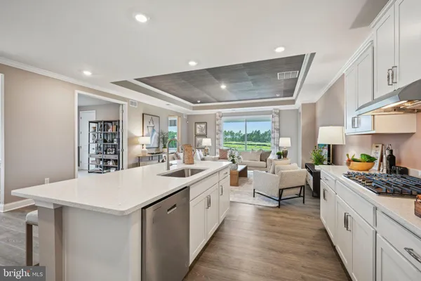 a kitchen with stainless steel appliances a sink a stove and wooden floor