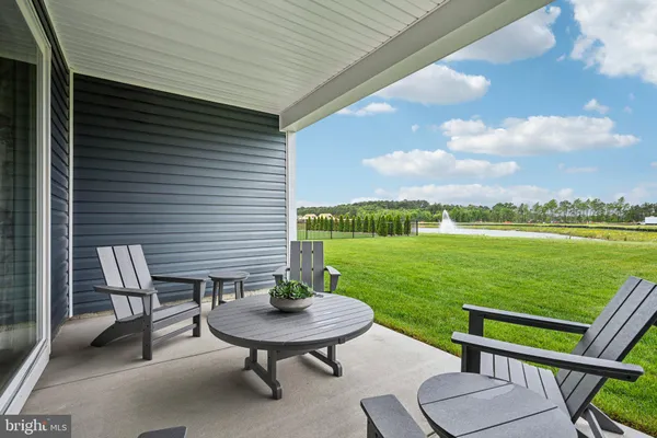 a view of a chairs and table in patio next to a yard