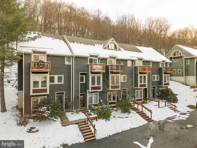 a view of a white house with large windows next to a road